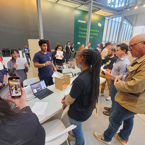 A crowd gathered around a team presenting their product